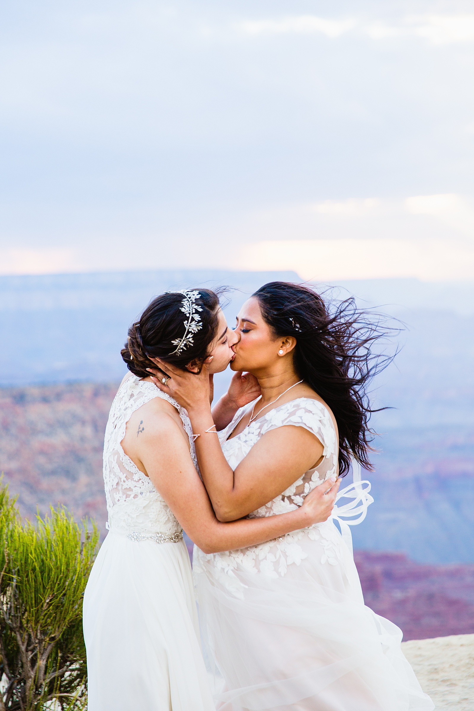 Same sex couple share their first kiss during their wedding ceremony at Moran Point by Arizona elopement photographer PMA Photography.