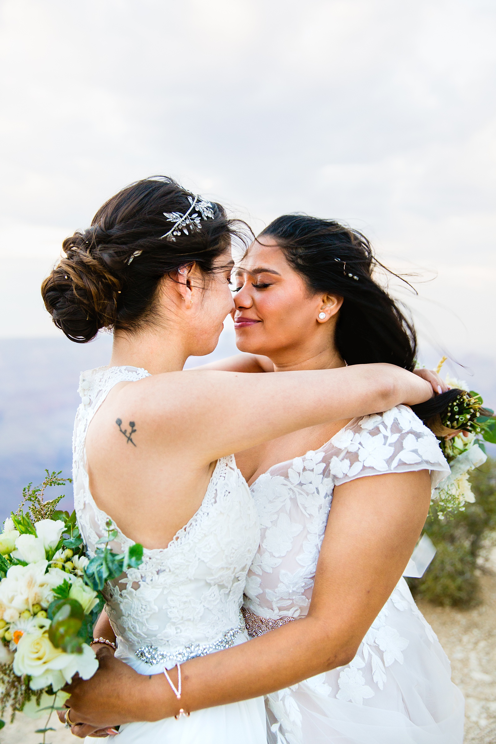 Adventurous lesbian couple share an intimate moment during their Moran Point elopement by Grand Canyon elopement photographer PMA Photography.