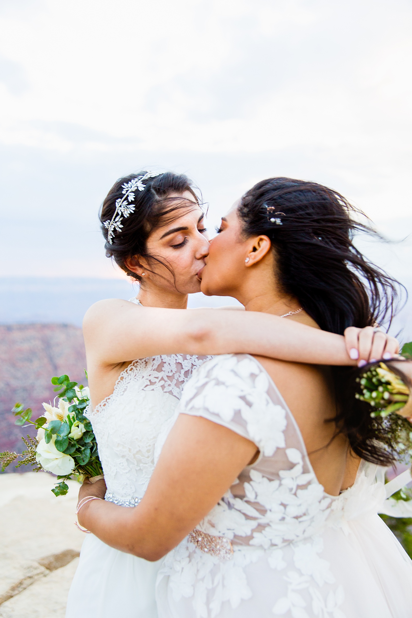 Adventurous lesbian couple share a kiss during their Moran Point elopement by Arizona elopement photographer PMA Photography.