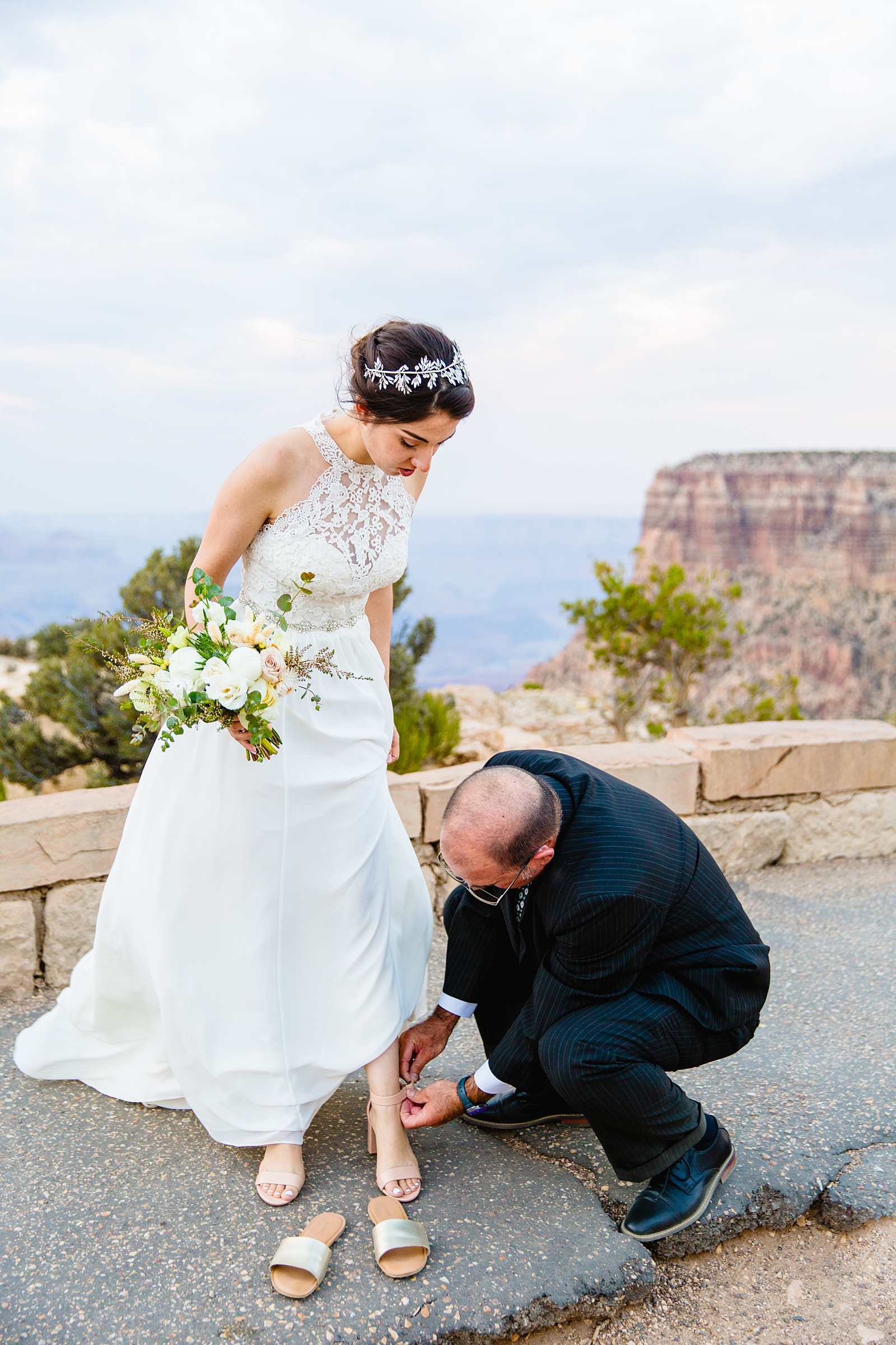 Brides dad helps her change her shoes after her Grand Canyon elopement by PMA Photography.
