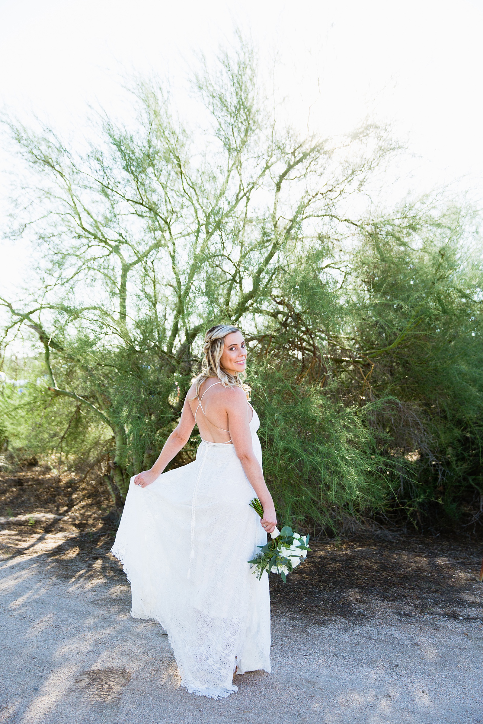 Bride twirling in her simple boho style dress for her Scottsdale backyard elopement by Arizona wedding photographer PMA Photography.