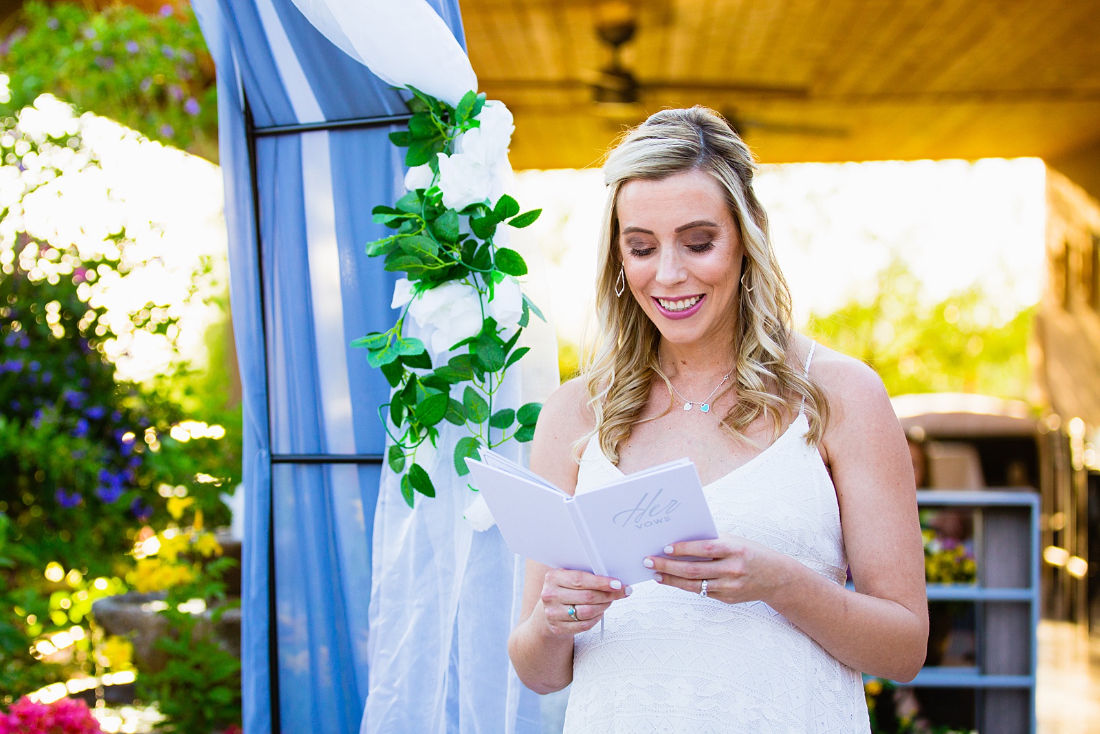 Bride reading vows to her groom during their wedding ceremony at a backyard by Scottsdale wedding photographer PMA Photography.