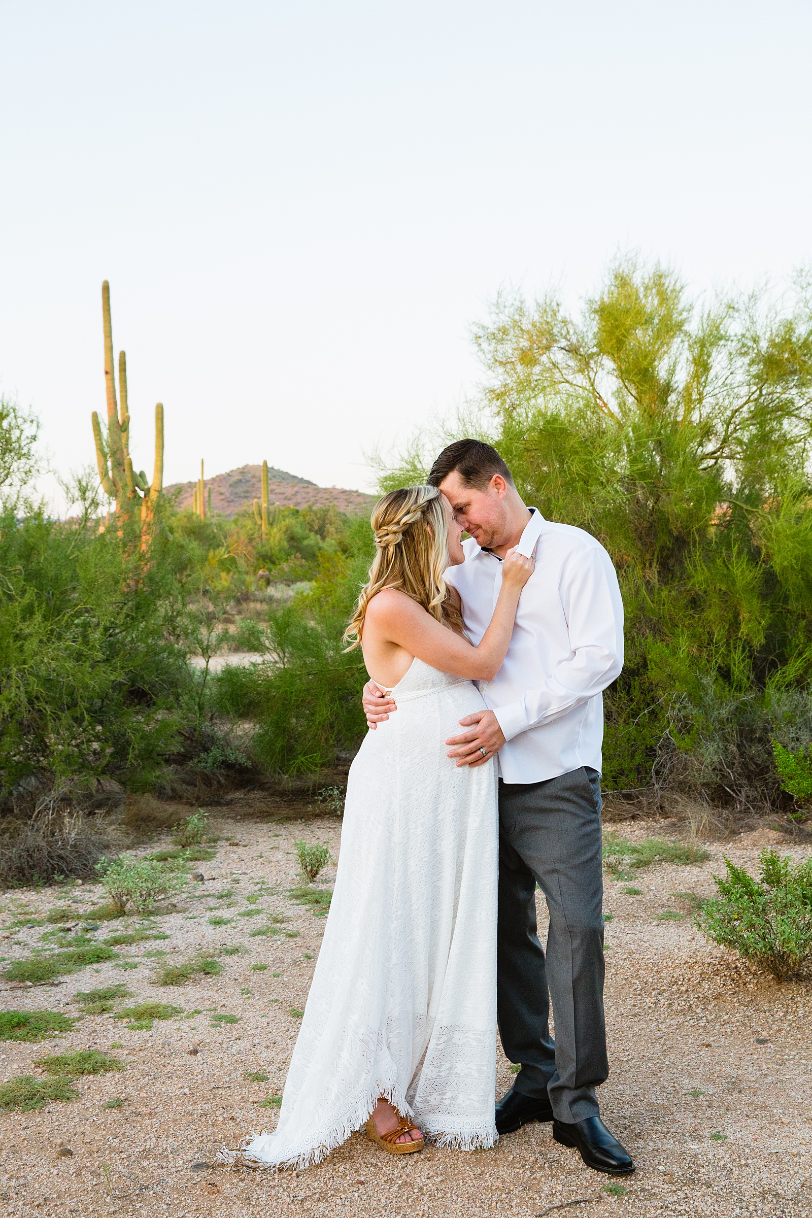 Pregnant bride and Groom share an intimate moment during their desert backyard elopement in Scottsdale by Arizona wedding photographer PMA Photography.