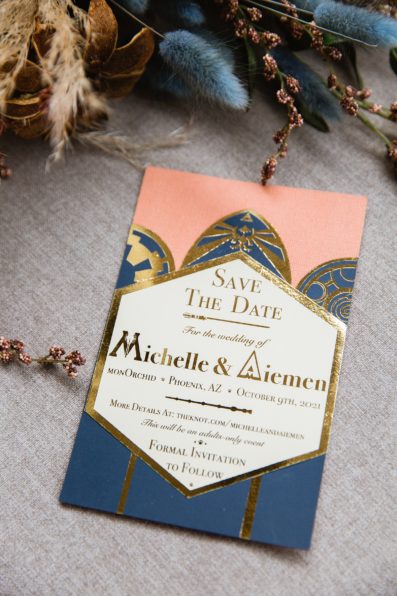 Art deco inspired peach and navy wedding invitations with nerdy hints of Harry Potter and Star Wars by Phoenix wedding photographer PMA Photography.