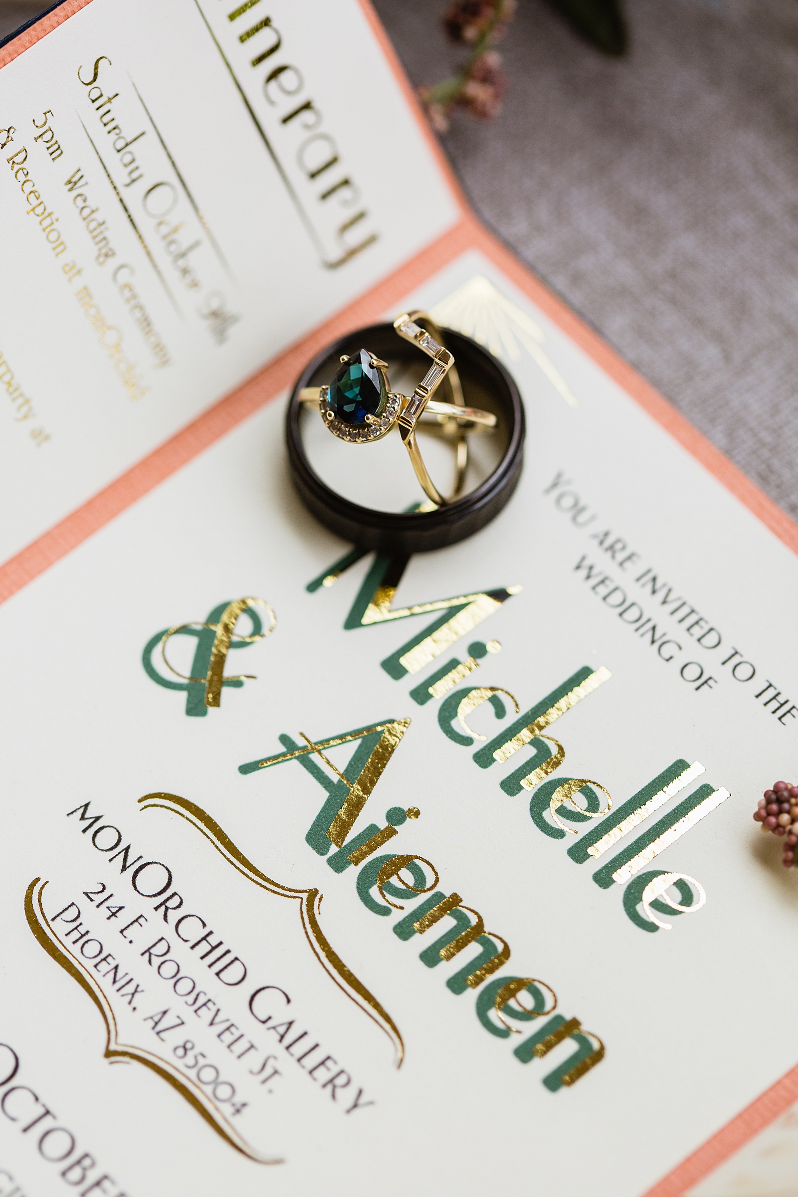 Unique emerald wedding ring set on top of art deco inspired wedding invitations by Phoenix wedding photographer PMA Photography.