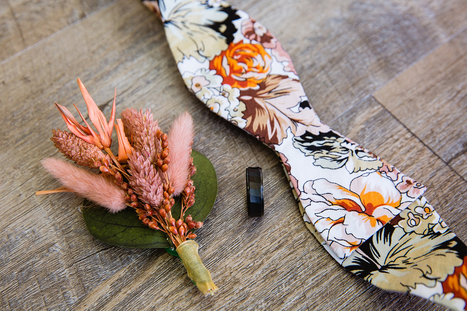 Groom's wedding day details of peach dried flower boutonniere and floral bowtie by PMA Photography.
