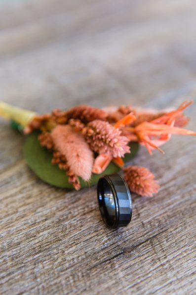 Groom's black wedding band with peach dried flower boutonniere by PMA Photography.