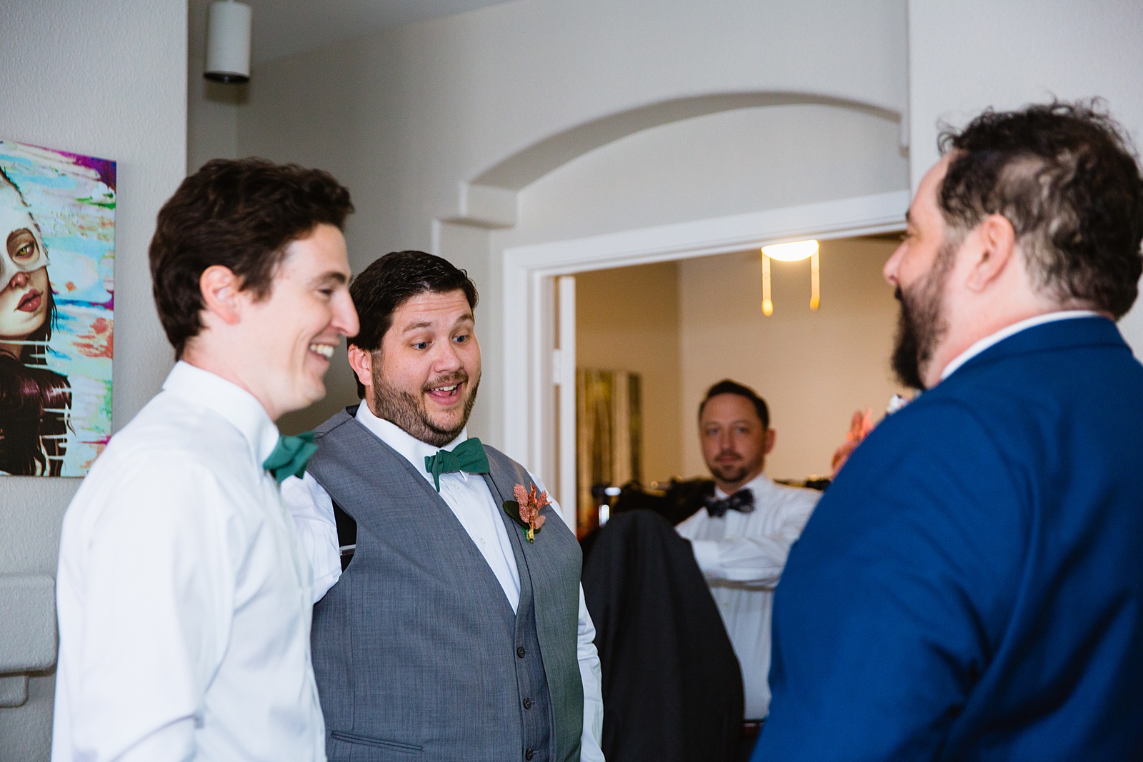 Groomsmen laughing together while getting ready by PMA Photography.