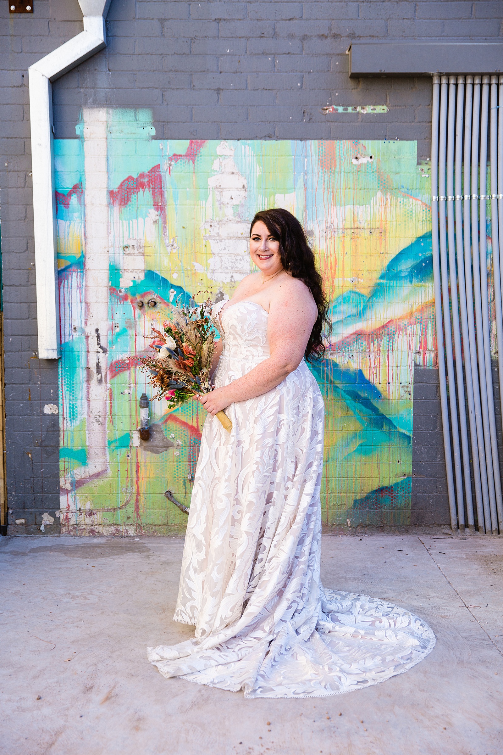 Bride's romantic blush wedding dress against a colorful mural for her MonOrchid wedding by PMA Photography.