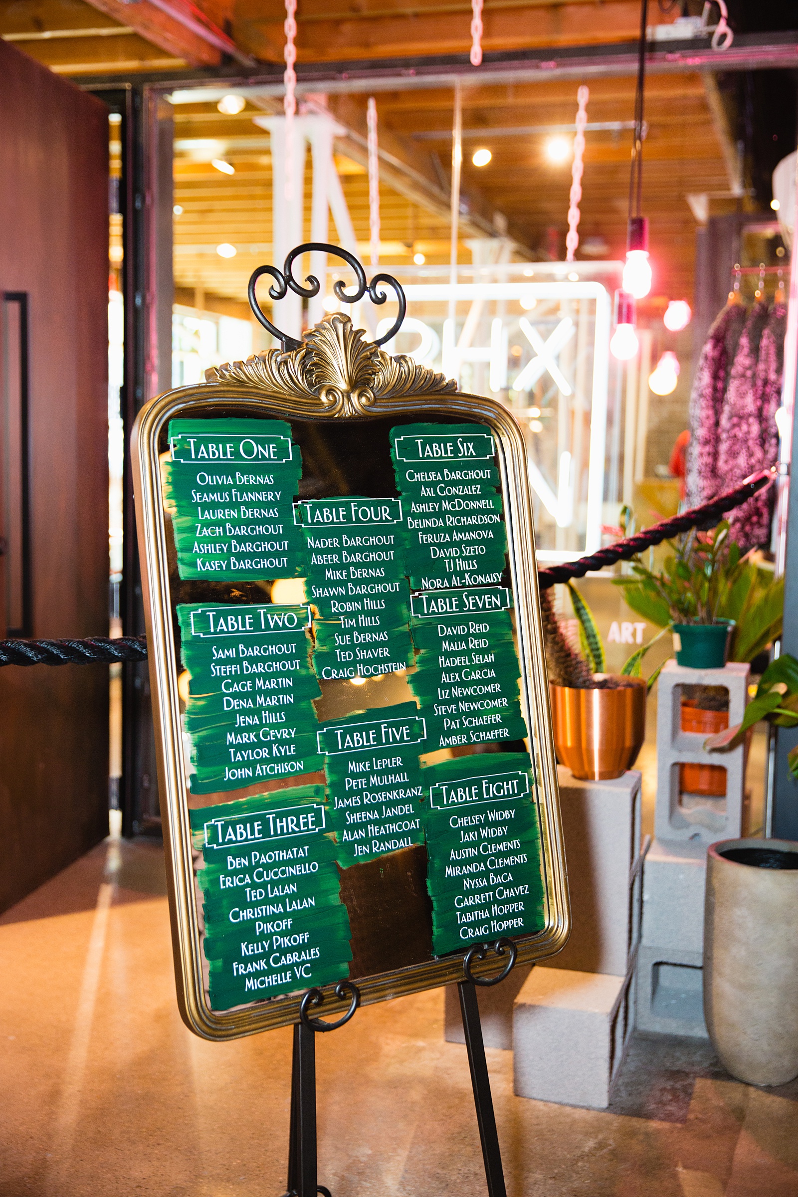 Unique art-deco inspired seating chart on a mirror with green brush strokes by Phoenix wedding photographer PMA Photography.