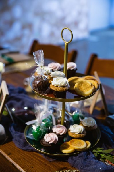 Cookies, cake pops, and mini cupcakes on a two tier tray as part of the favors and reception table decoration at a MonOrchid wedding by Phoenix wedding photographers PMA Photography.