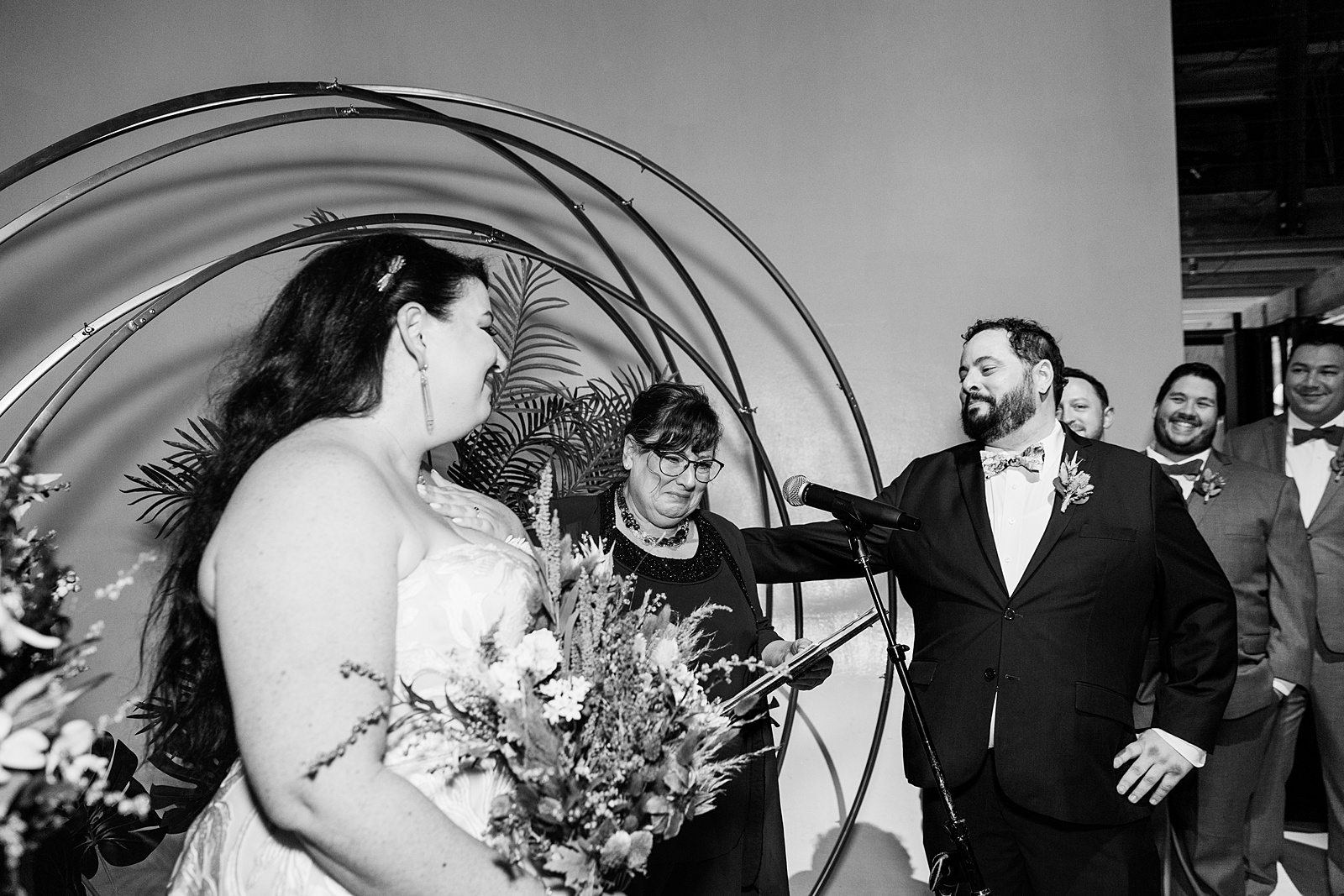 Officiant and mother of the groom crying as she officiates the wedding ceremony at MonOrchid by Arizona wedding photographer PMA Photography.