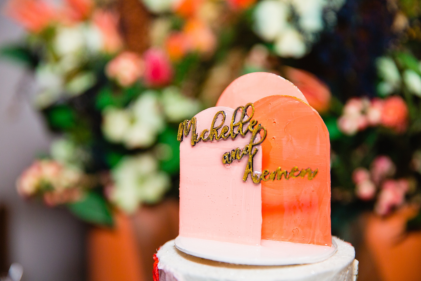 Peachy toned art deco inspired wedding cake topper with the couple's name in gold by Arizona wedding photographer PMA Photography.