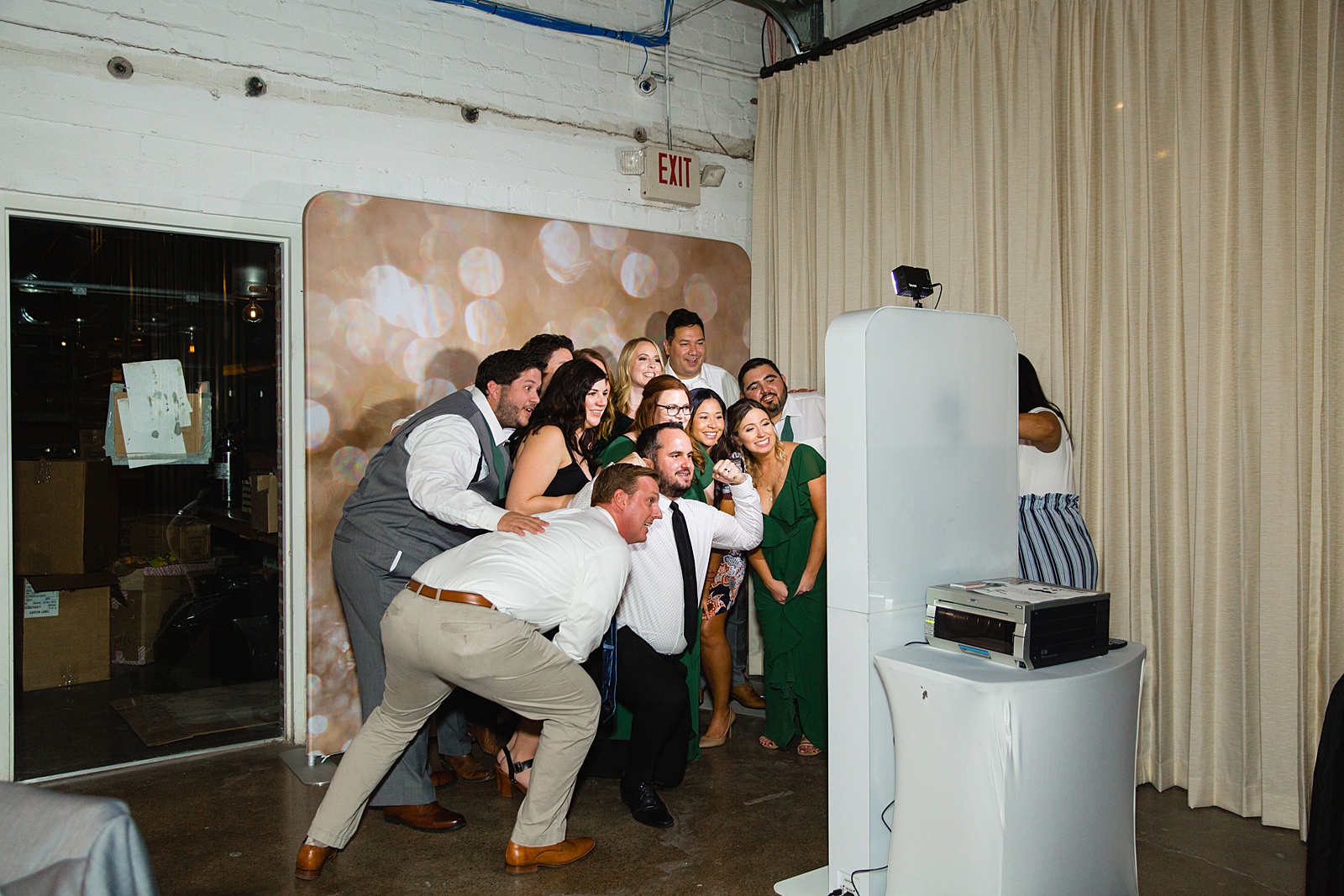 Guests pose together in a photo booth by Phoenix wedding photographer PMA Photography.