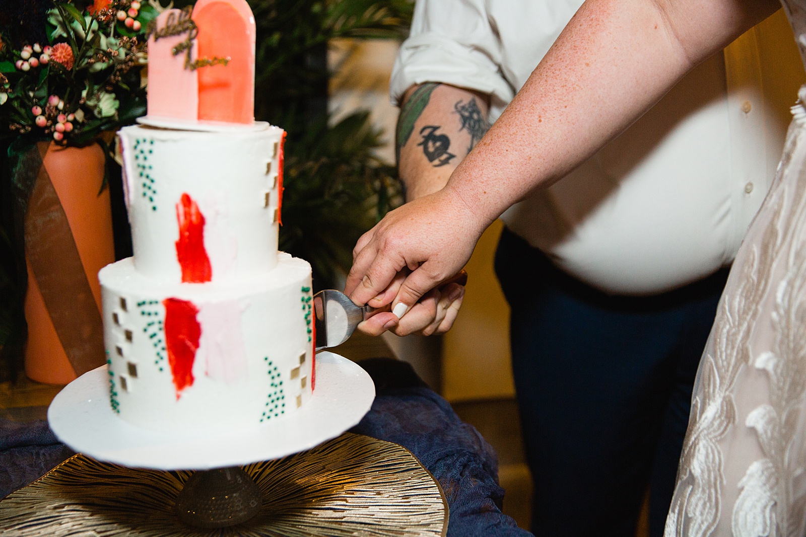Bride and Groom cutting their wedding cake at their MonOrchid wedding reception by Arizona wedding photographer PMA Photography.