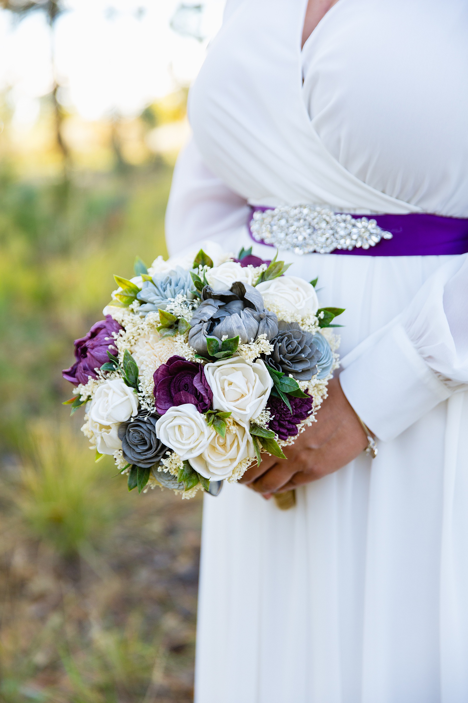 Bride's purple, blue, and white wooden flower bouquet by PMA Photography.