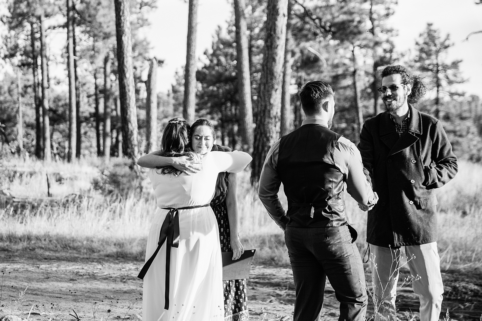 Bride and groom hugging friends that arrived to their elopement by Arizona wedding photographer PMA photography.
