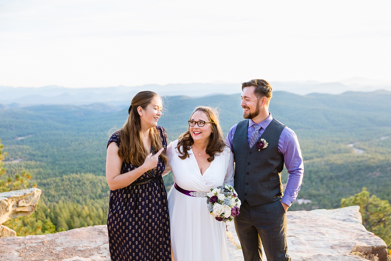 Bride and groom laugh with their friend and officiant of their elopement on the Mogollon Rim by Arizona wedding photographer PMA Photography.