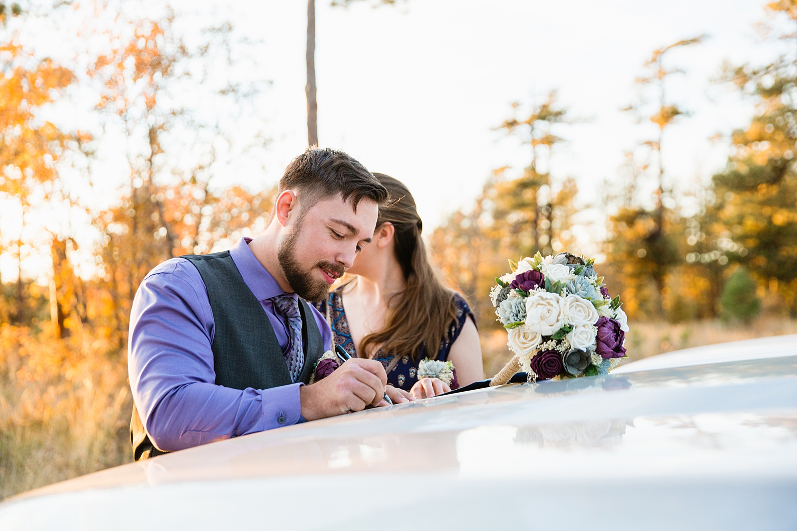 Groom signing the marriage license on after their wedding ceremony at Mogollon Rim by Payson elopement photographer PMA Photography.