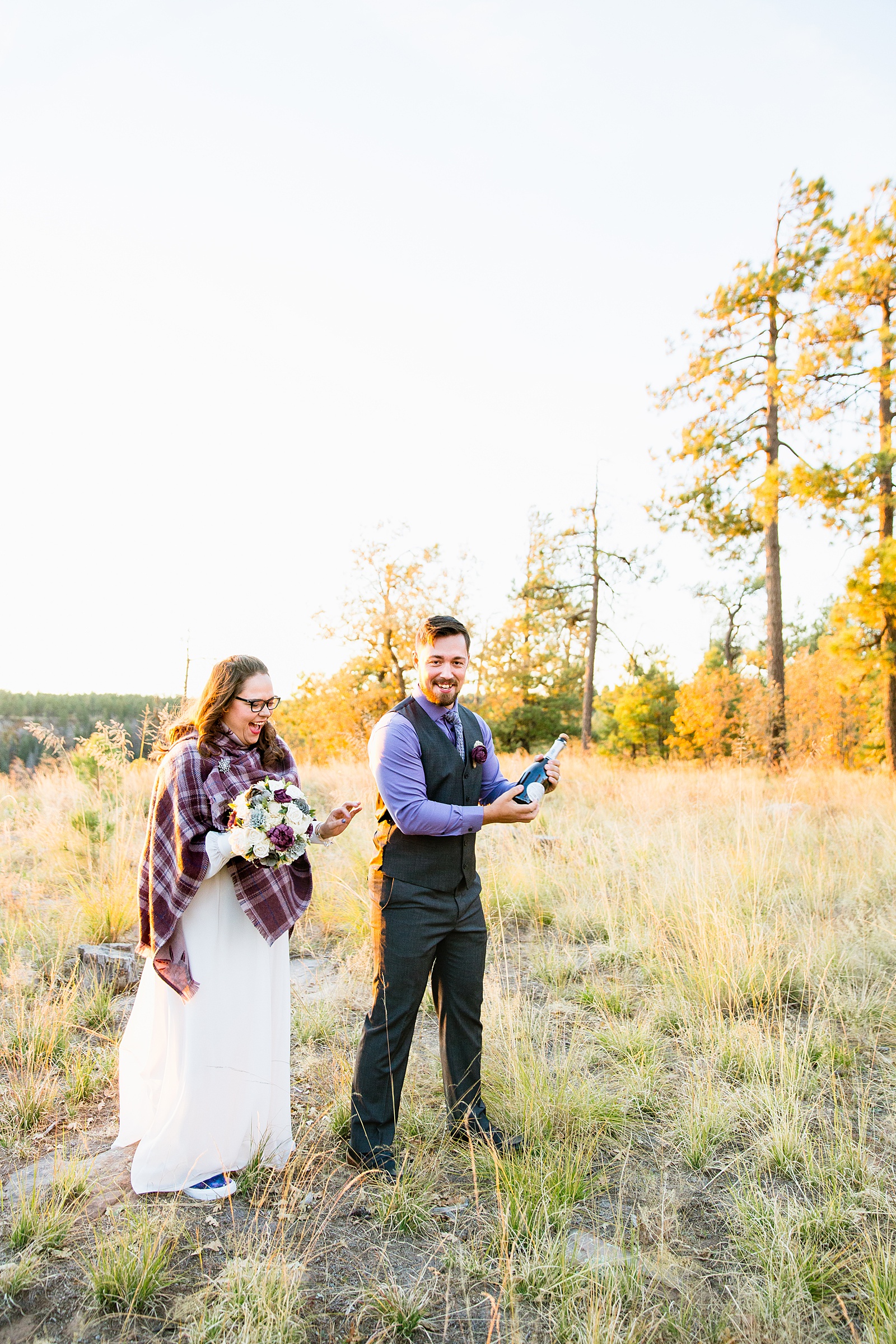 Bride and groom popping champagne to celebrate their Mogollon Rim elopement by Payson elopement photographer PMA Photography.