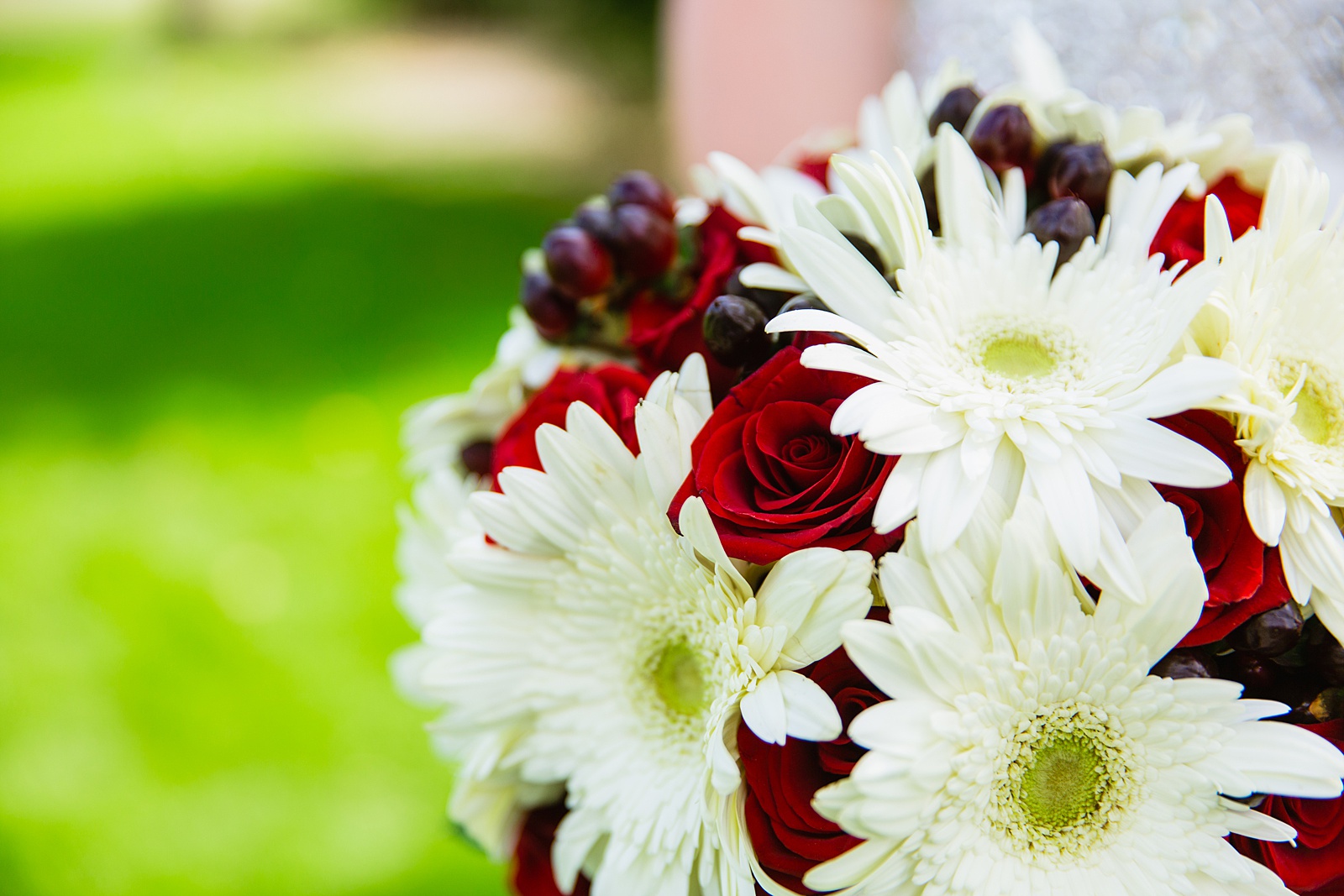 Bride's white daisy and red rose bouquet by PMA Photography.