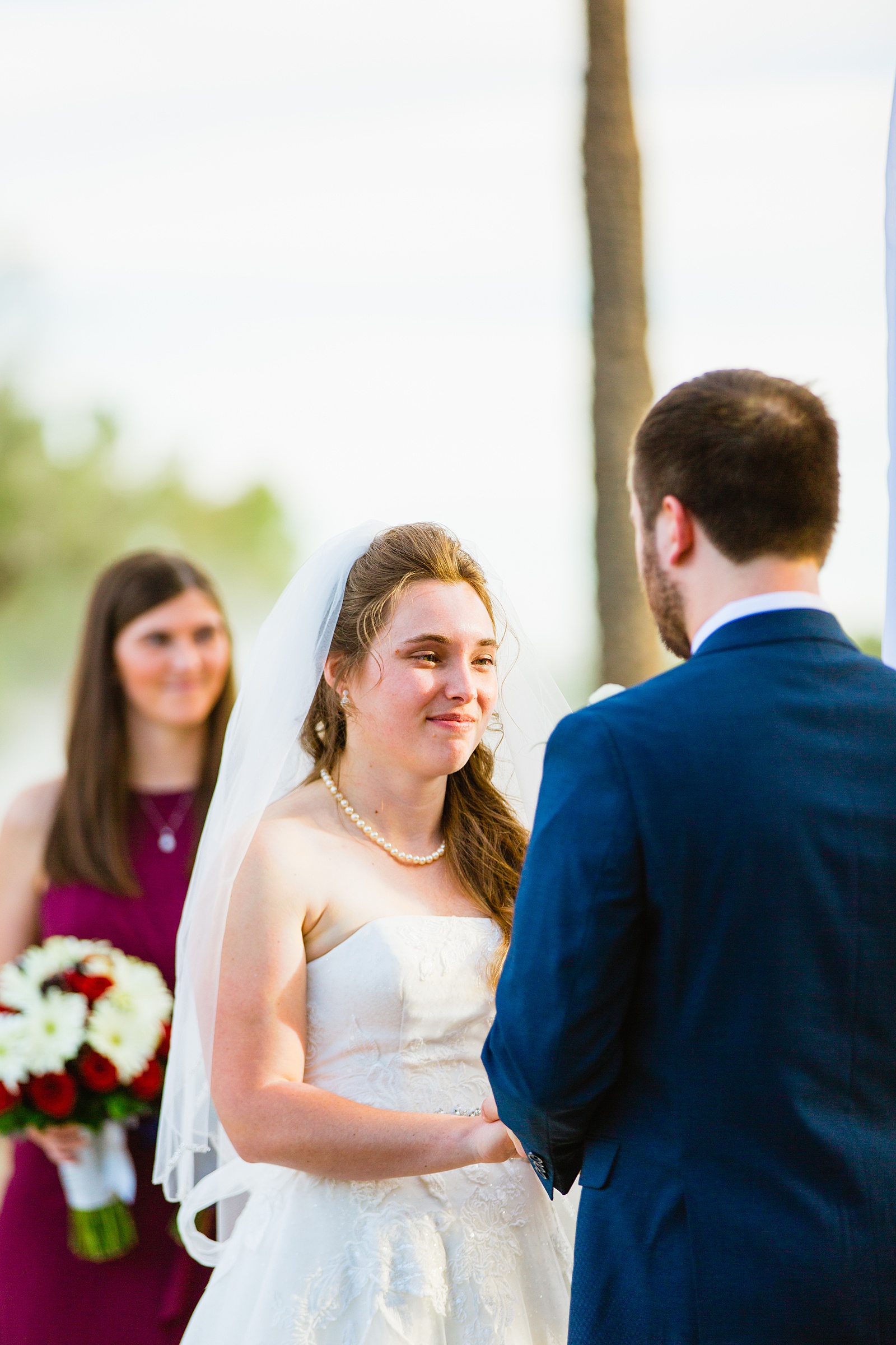 Bride looking at her groom during their wedding ceremony at Ocotillo Oasis by Phoenix wedding photographer PMA Photography.
