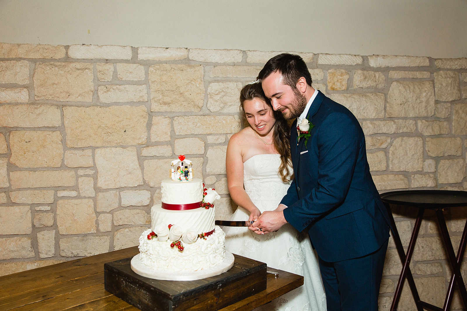 Bride and Groom cutting their wedding cake at their Ocotillo Oasis wedding reception by Arizona wedding photographer PMA Photography.