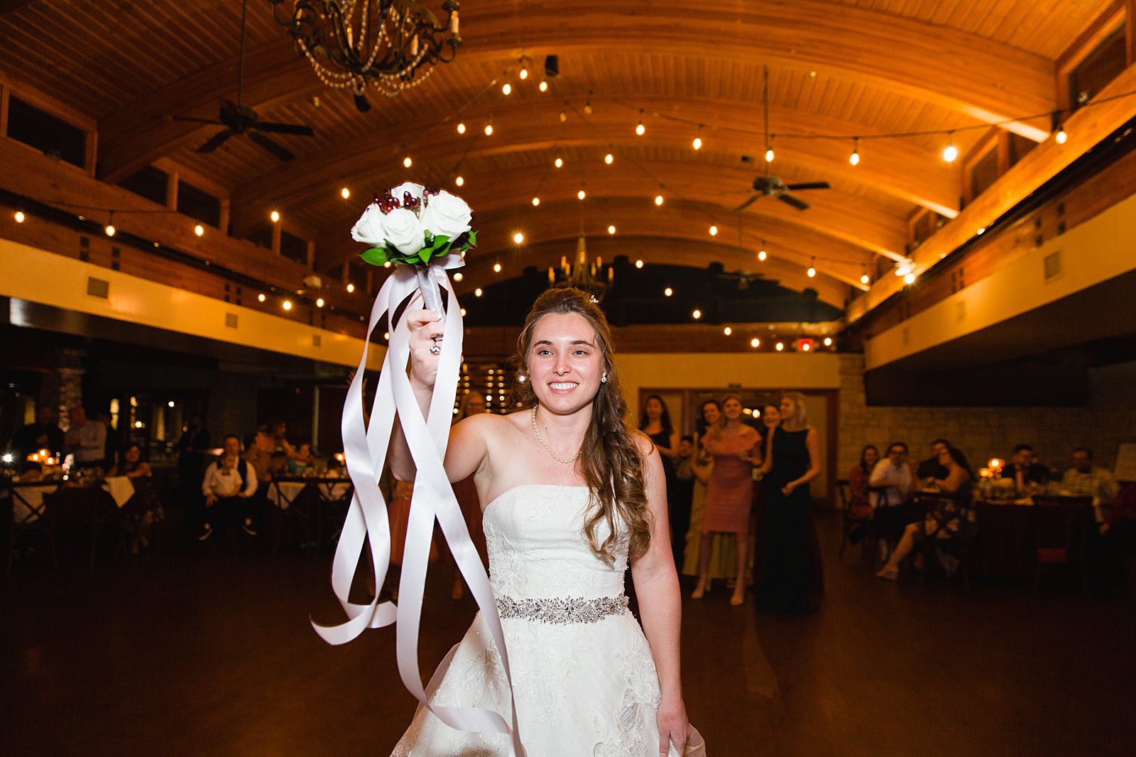 Bouquet toss at Ocotillo Oasis wedding reception by Phoenix wedding photographer PMA Photography.
