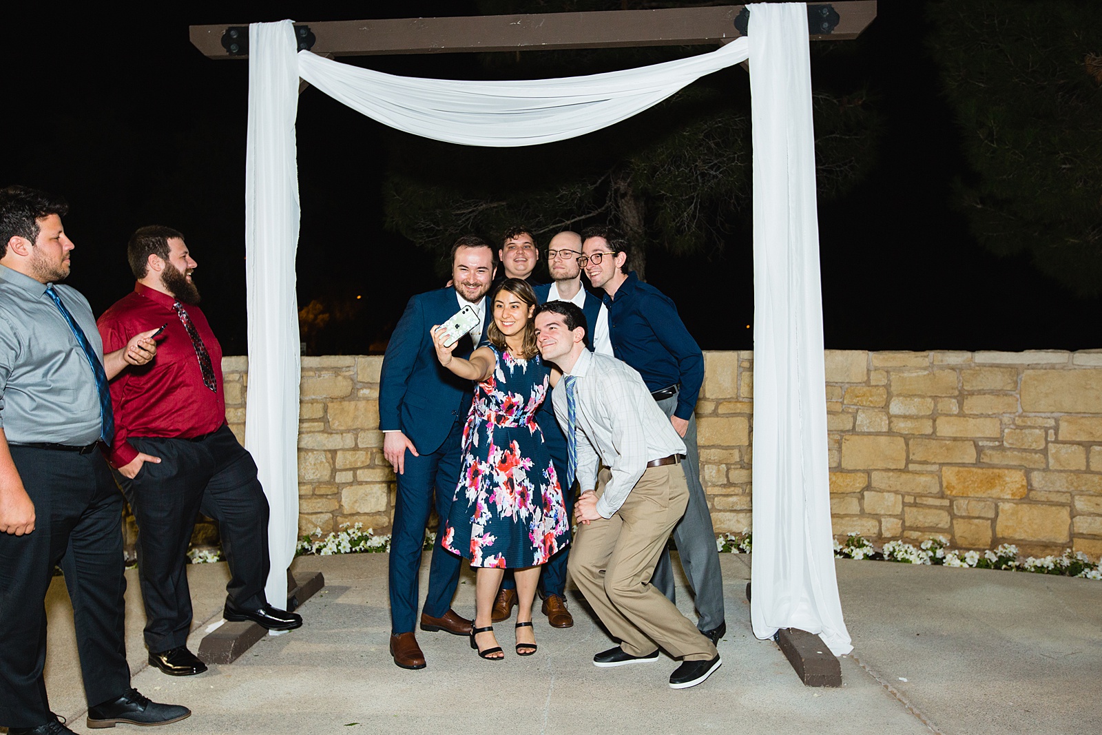 Candid photo of the groom taking a selfie with guest by Arizona wedding photographer PMA Photography.