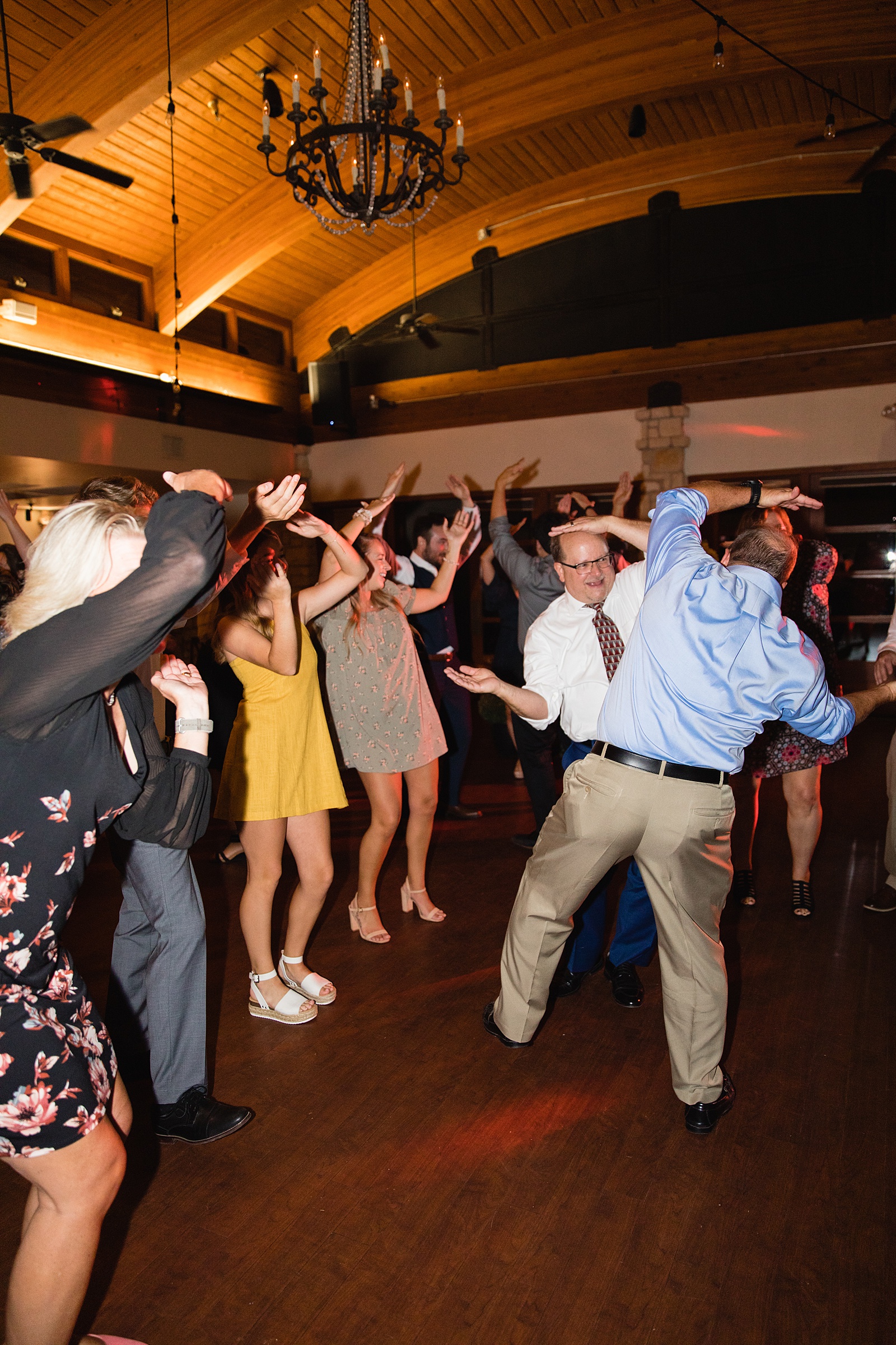Candid image of guests dancing together at their Ocotillo Oasis wedding reception by Arizona wedding photographer PMA Photography