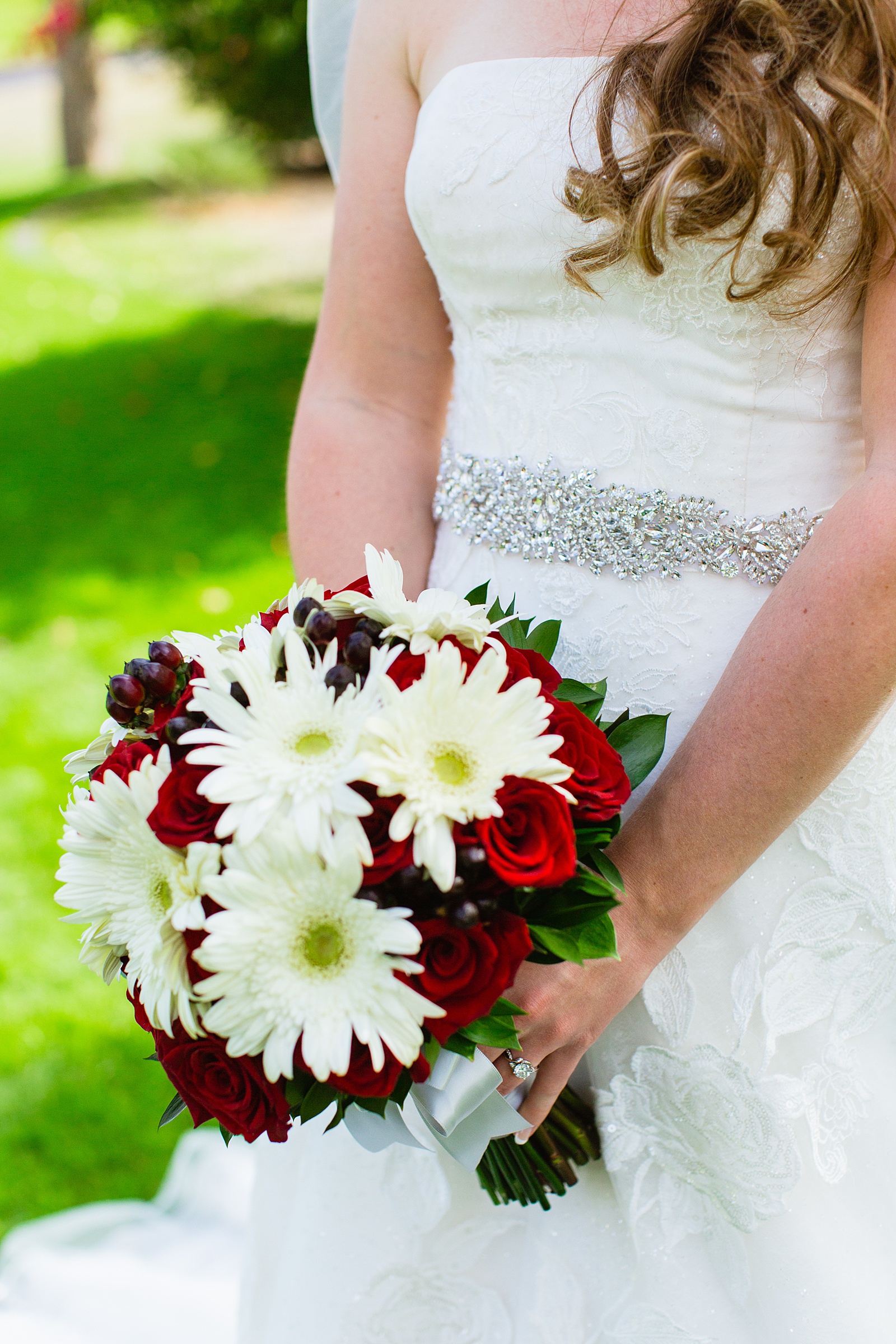 Bride's white daisy and red rose bouquet by PMA Photography.