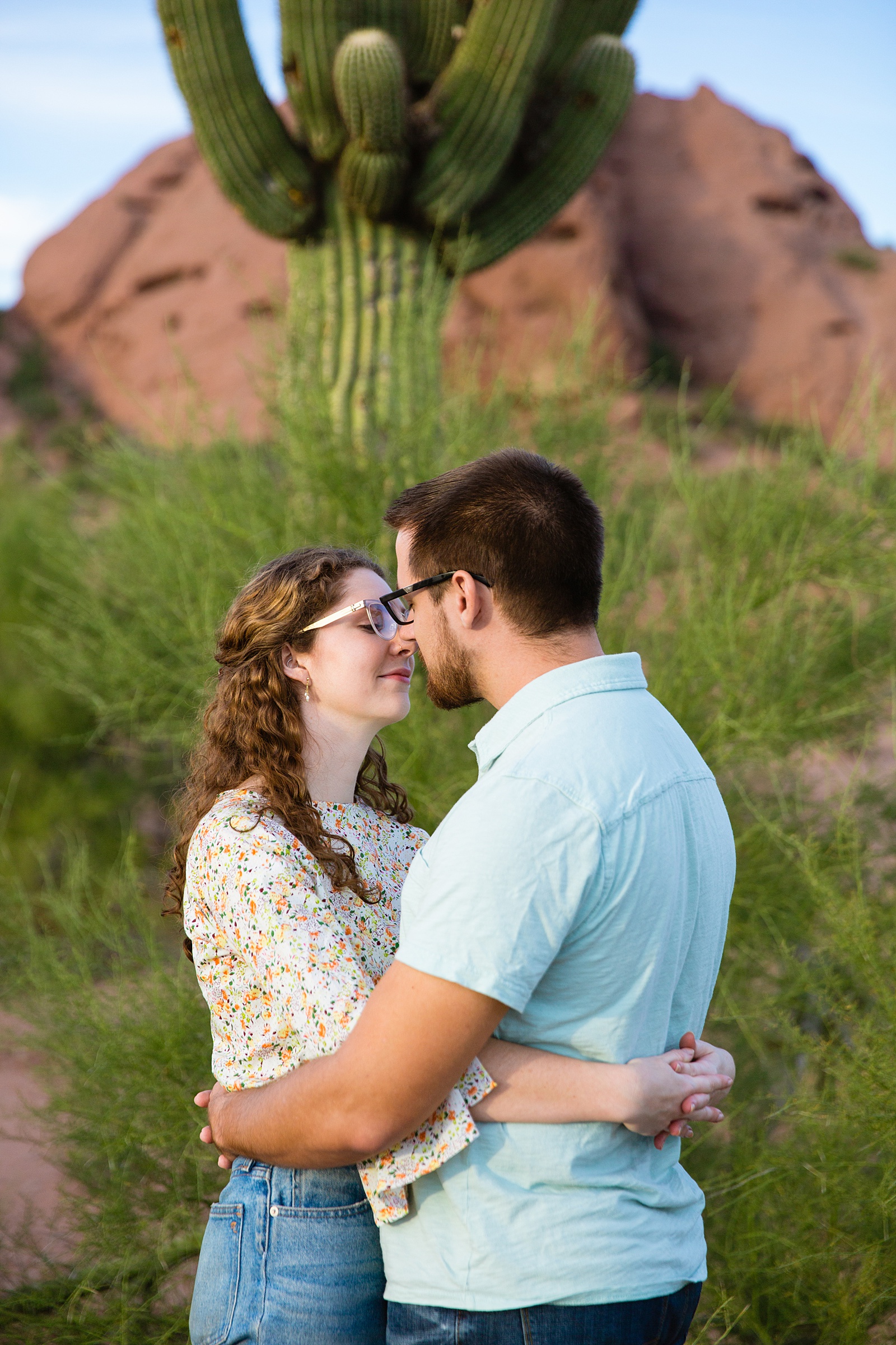 Couple share an intimate moment during their Papago Park engagement session by Phoenix engagement photographer PMA Photography.