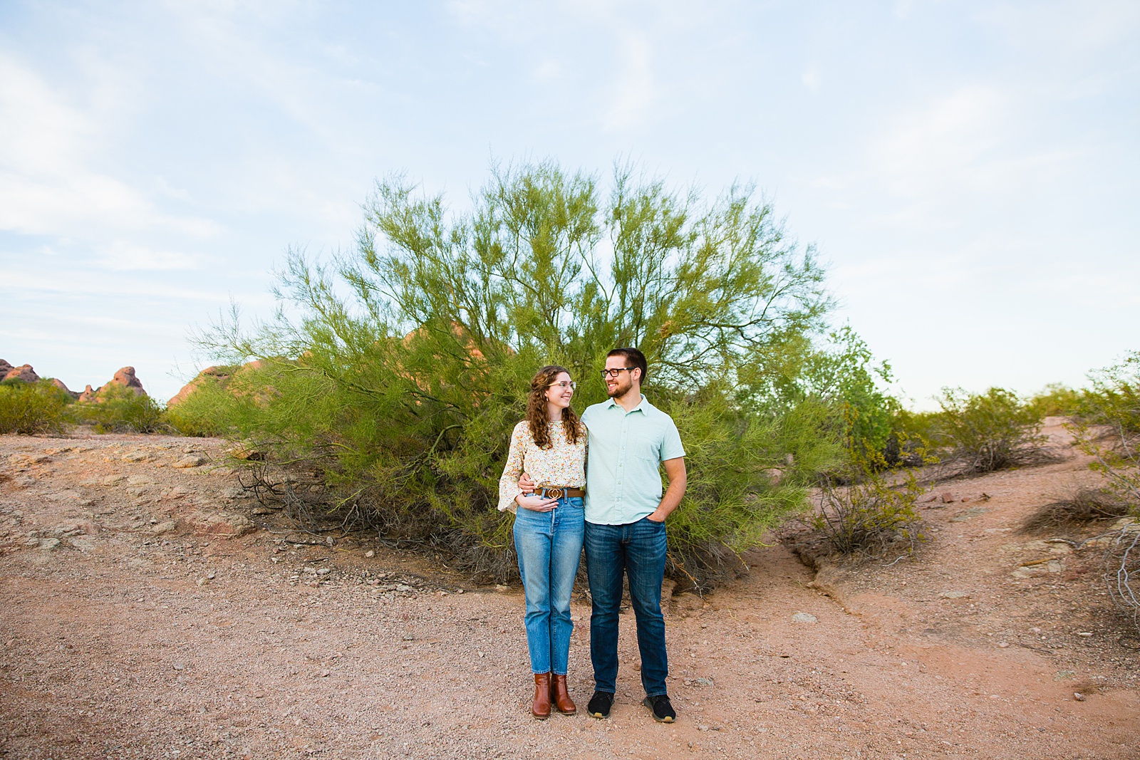 Couple look at each other during their Phoenix engagement session by Arizona wedding photographer PMA Photography.