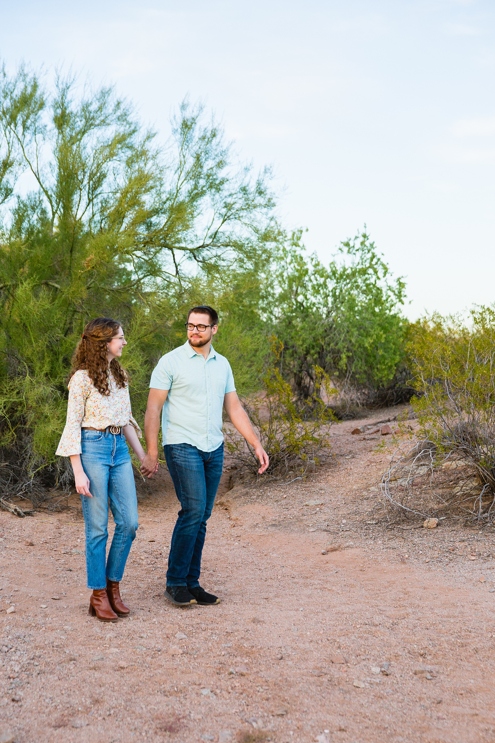 Couple walking together during their Papago Park engagement session by Phoenix engagement photographer PMA Photography.