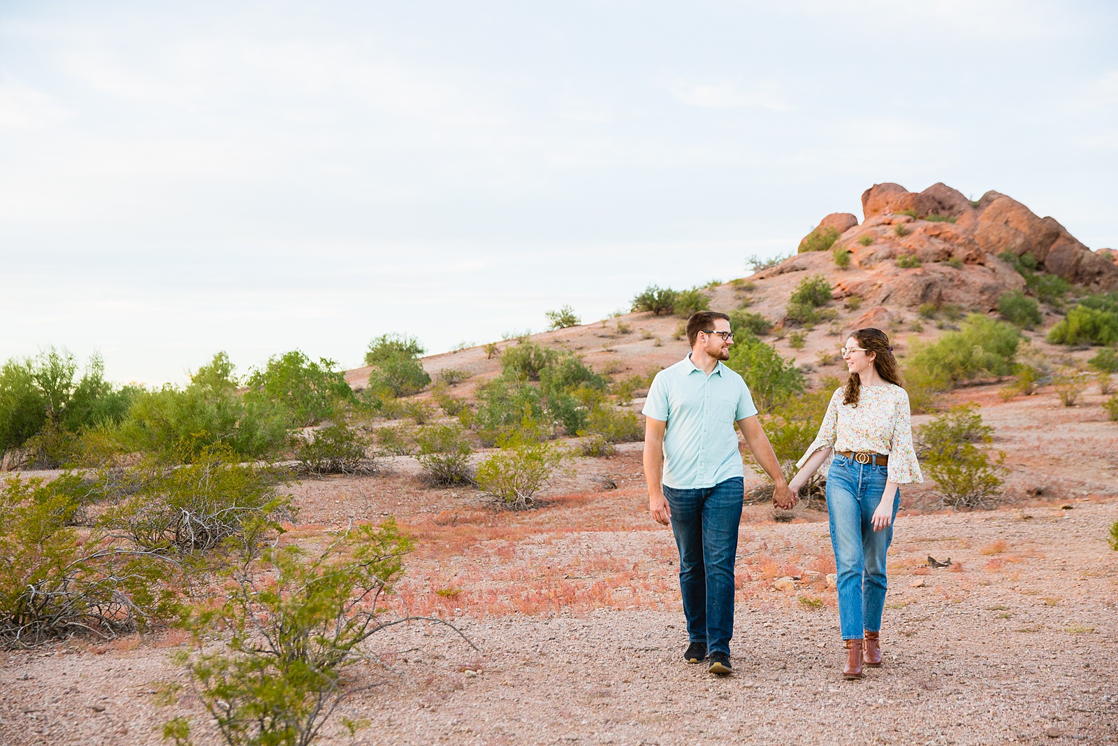 Couple walking together during their Phoenix engagement session by Arizona engagement photographer PMA Photography.