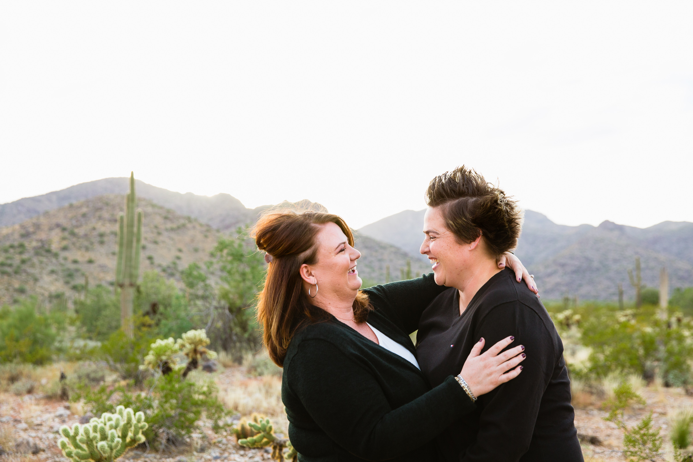 Couple laugh together during their Waddell anniversary session by Arizona engagement photographer PMA Photography.