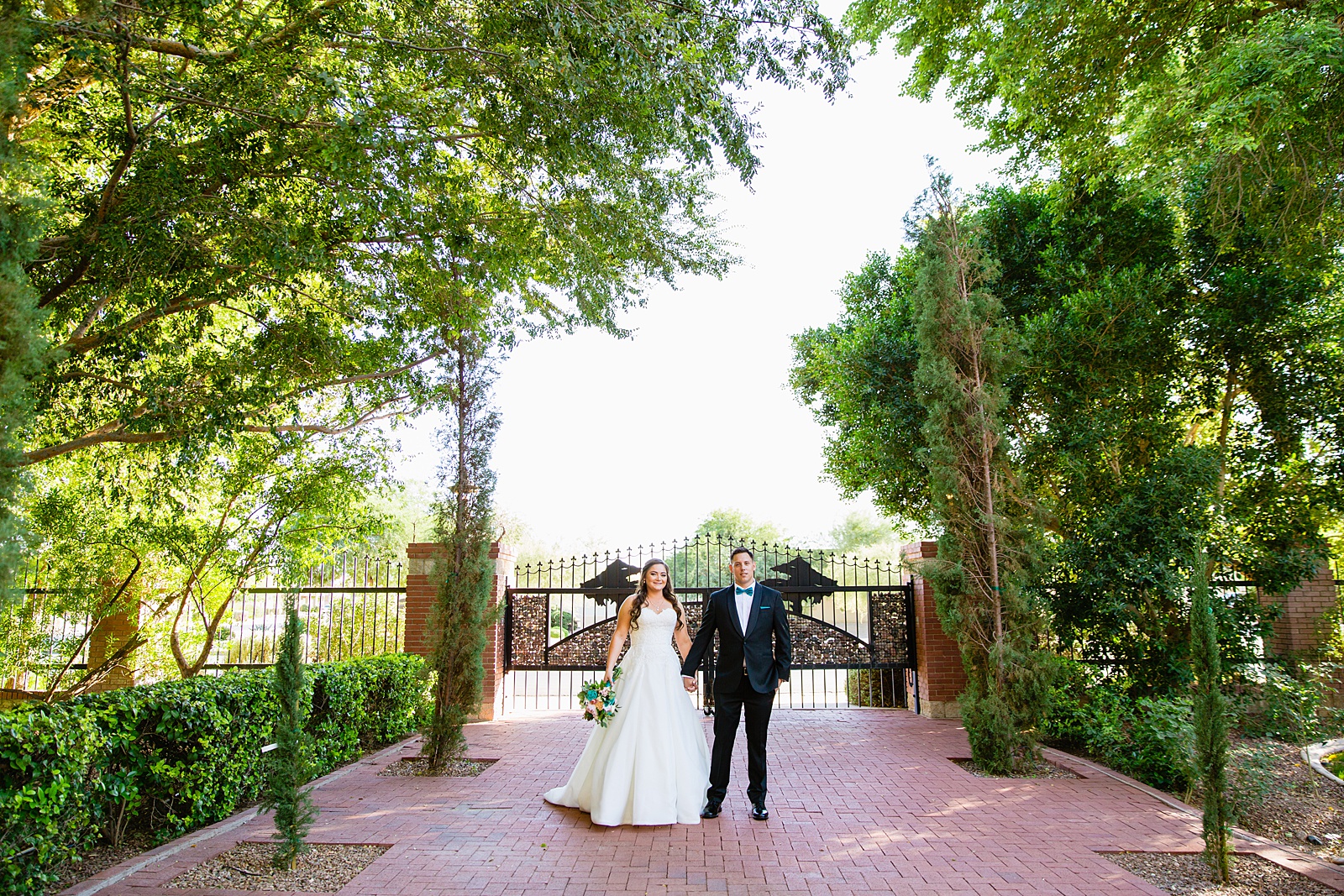 Bride and groom walking together during their Stonebridge Manor wedding by Arizona wedding photographer PMA Photography.