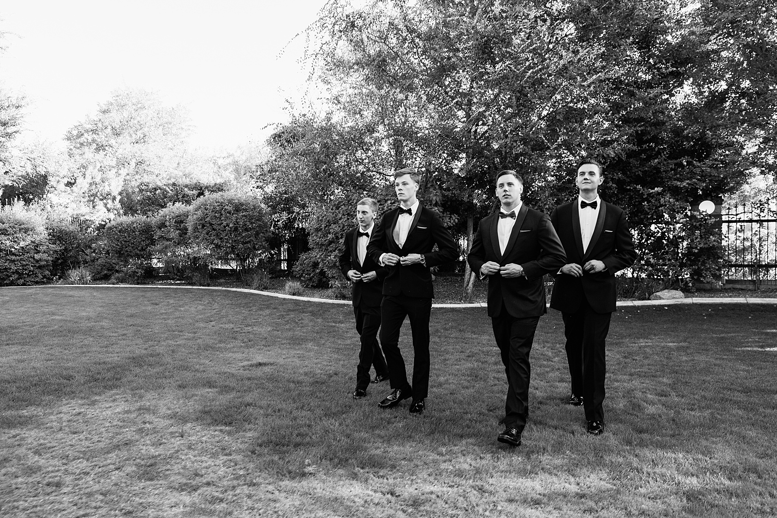 Groom and groomsmen walking together at a Stonebridge Manor wedding by Arizona wedding photographer PMA Photography.
