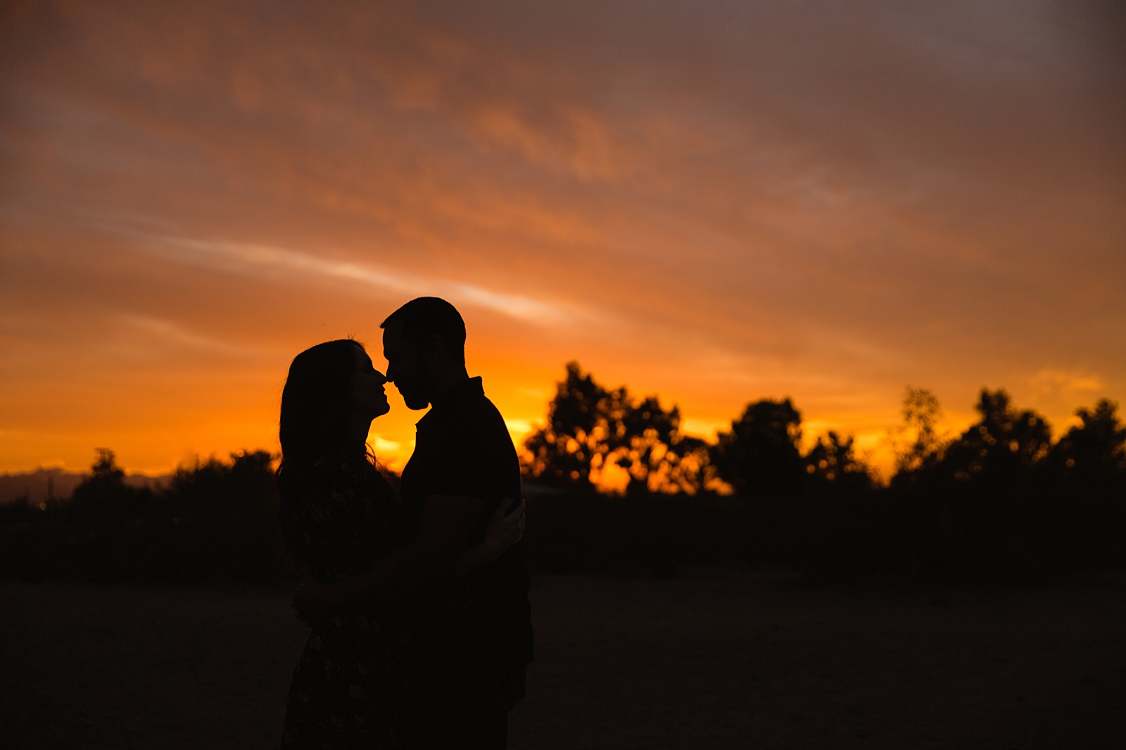 Sunset as couple share an intimate moment at their Phoenix engagement session by Arizona engagement photographer PMA Photography.