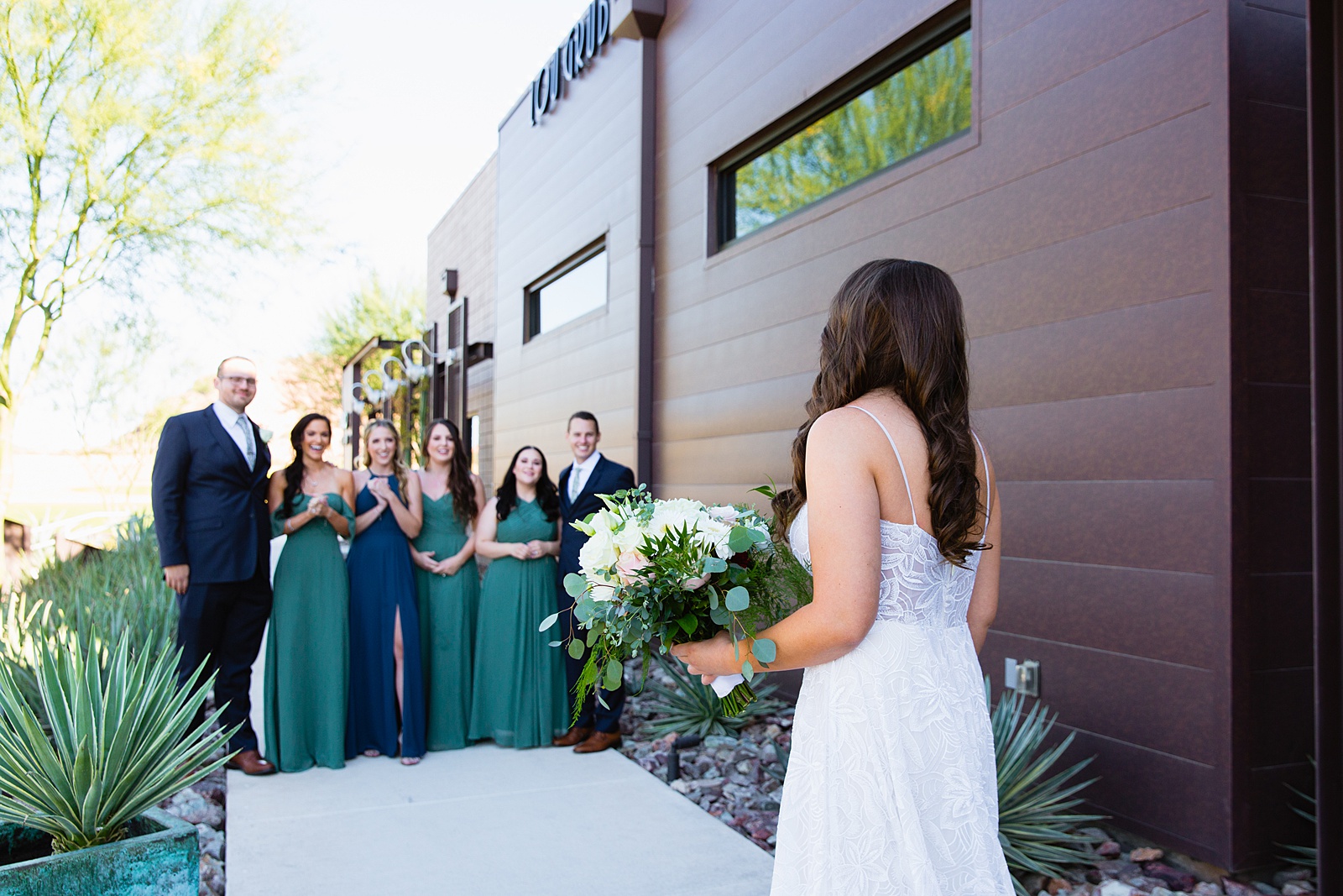 Bride's first look with her bridesmaids and bridesmen by Phoenix wedding photographer PMA Photography.