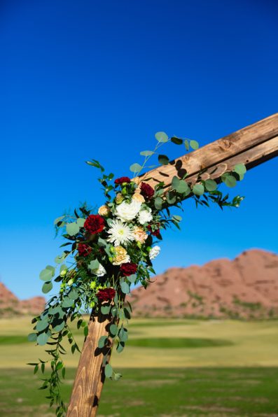 Hexagon wedding arch with white and red florals at Papago Events by Phoenix wedding photographer PMA Photography.