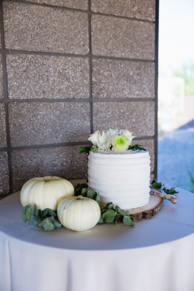 Simple white sweetheart cake with white pumpkins at a Papago Events wedding reception by wedding photographer PMA Photography.