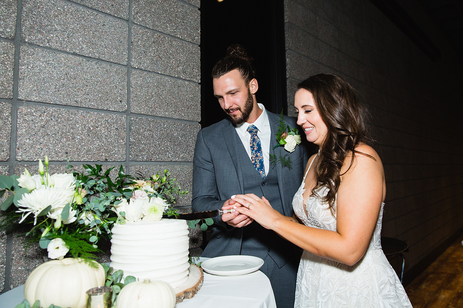 Bride and groom cutting their wedding cake at their Papago Events wedding reception by Arizona wedding photographer PMA Photography.