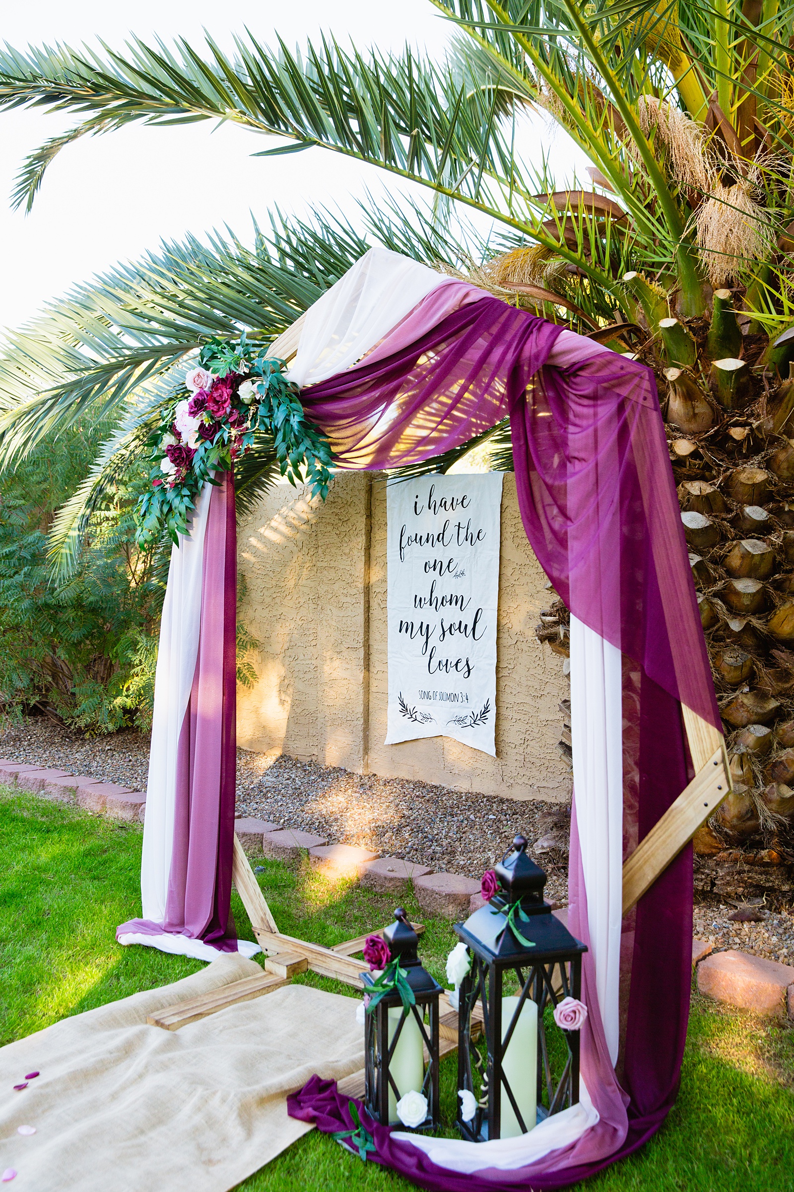 Wedding ceremony hexagon arch with maroon and white fabric and flowers at Backyard Micro by Phoenix wedding photographer PMA Photography.