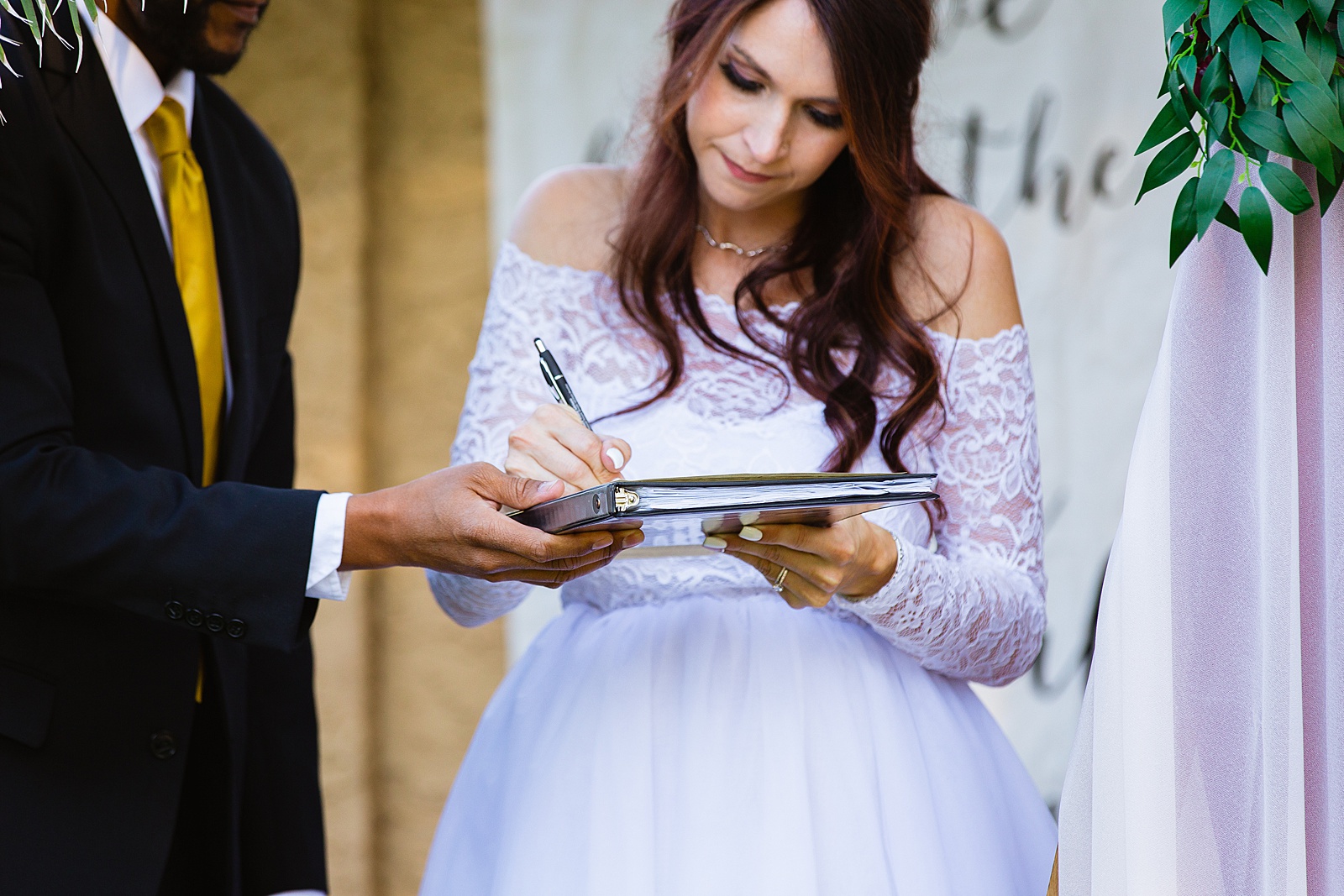 Bride signing the marriage license by PMA Photography.
