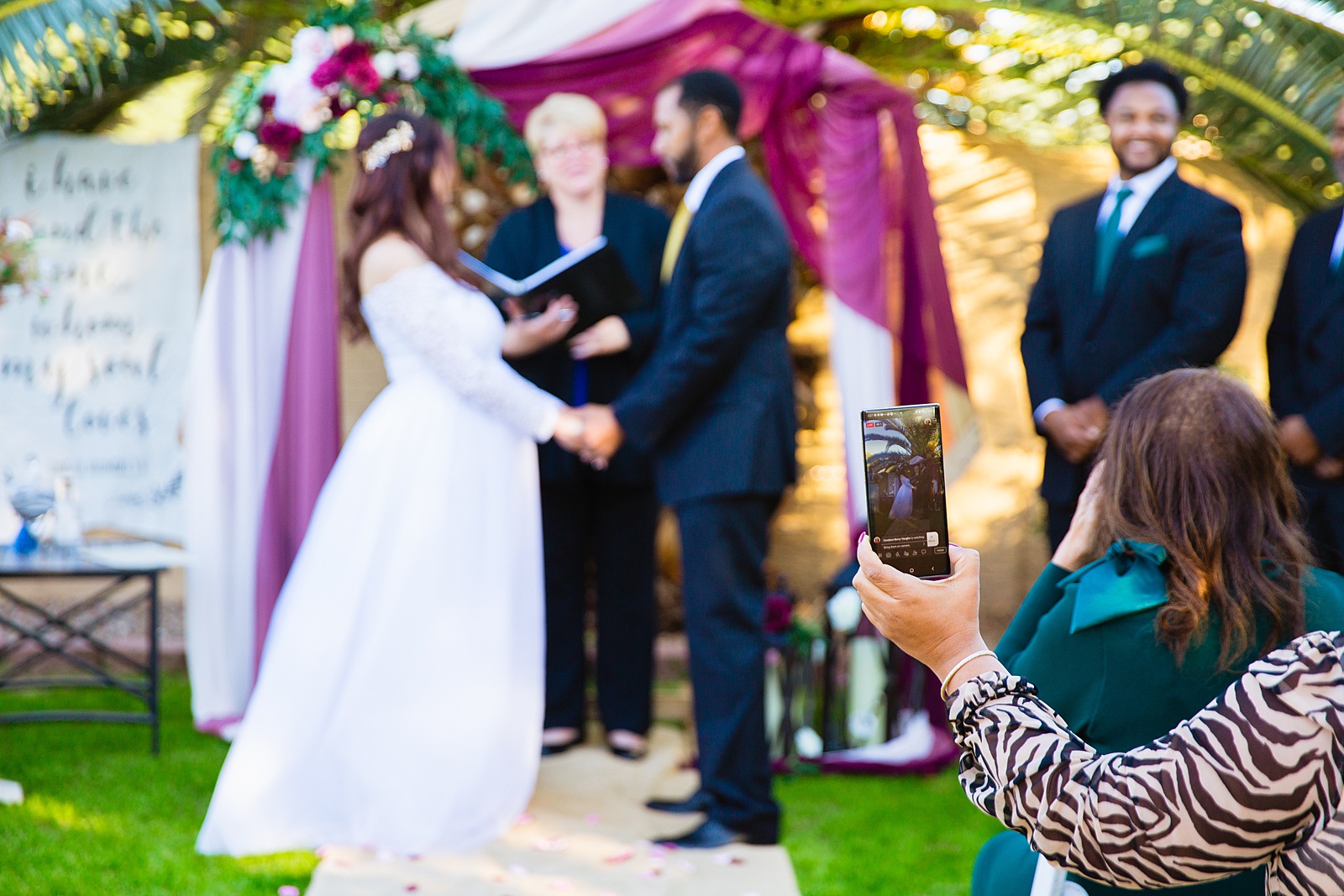 Guest taking video of the micro wedding ceremony by Scottsdale wedding photographer PMA Photography.