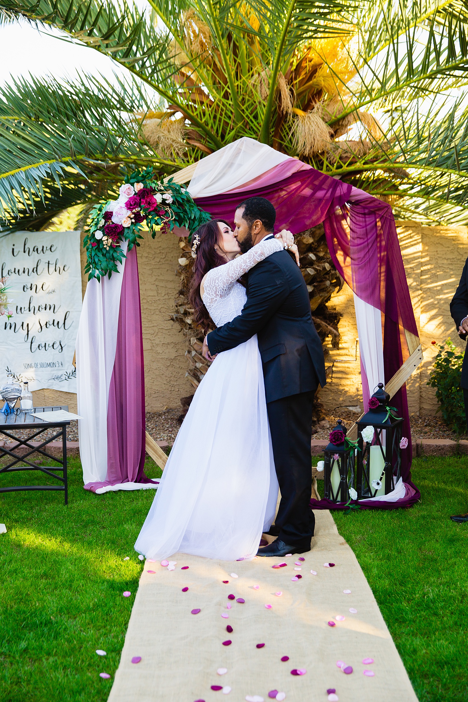Bride and groom share their first kiss during their wedding ceremony at Backyard Micro by Arizona wedding photographer PMA Photography.