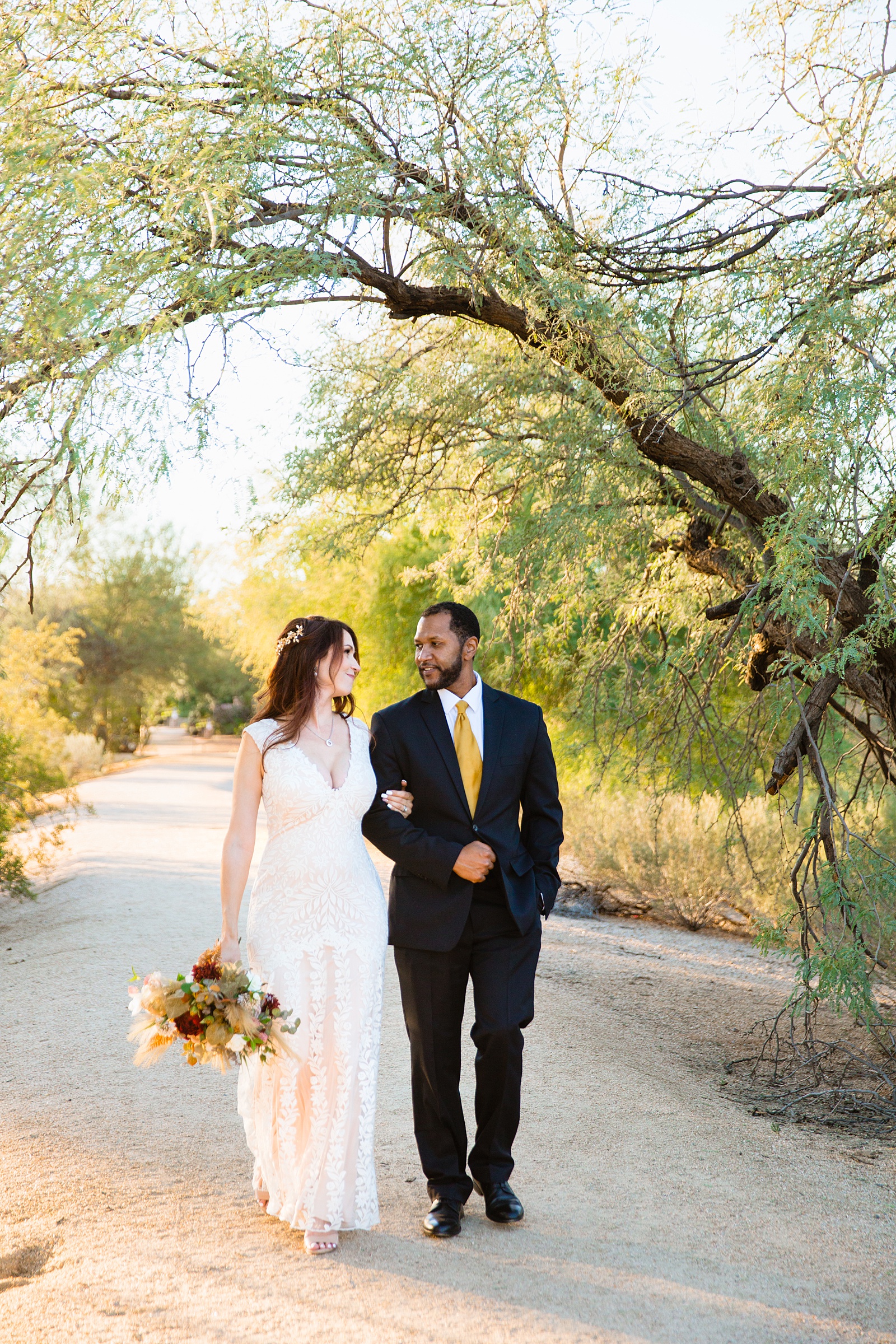 Bride and groom walking together during their Backyard Micro wedding by Arizona wedding photographer PMA Photography.