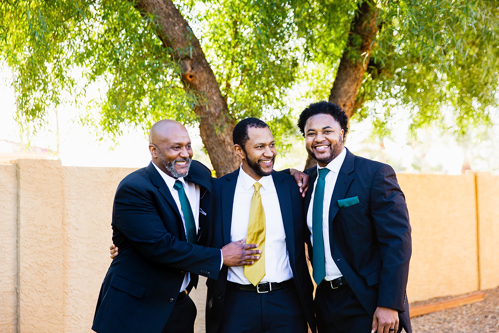 Groom and groomsmen laughing together at Backyard Micro wedding by Scottsdale wedding photographer PMA Photography.