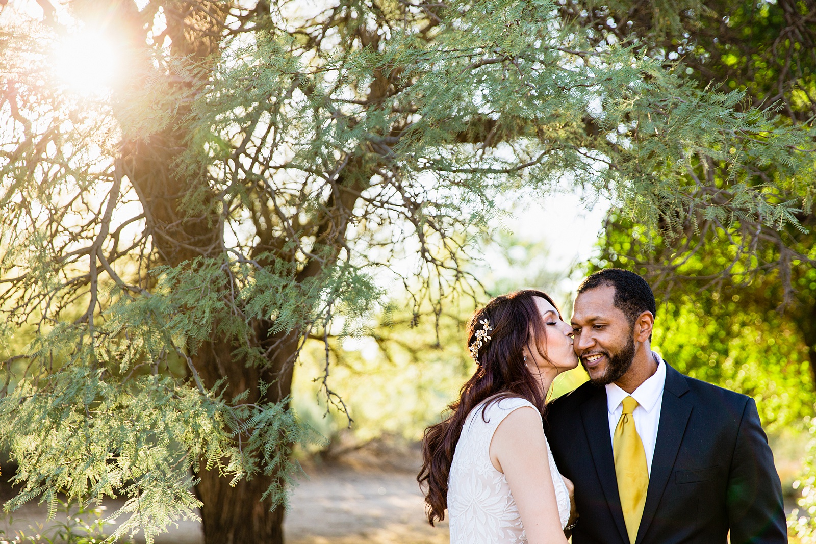 Bride and groom share a kiss during their Backyard Micro wedding by Scottsdale wedding photographer PMA Photography.